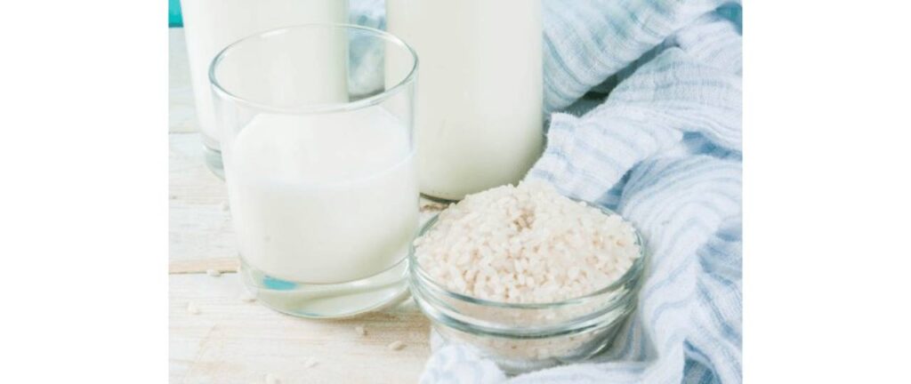 Garrafa de leite, um copo de leite e pote arroz sobre
